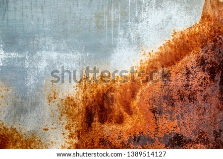 Background of weathered and rusted metal panel with oranges, browns and grays with lines and scratches
