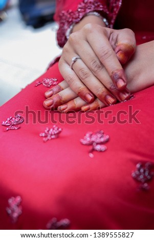 Hands of a bride decorated with henna and wedding ring. Traditional malay wedding. Soft focus image.