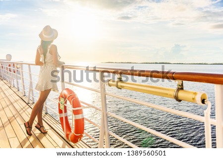 Luxury cruise ship travel elegant tourist woman watching sunset on balcony deck of Europe mediterranean cruising destination. Summer vacation cruiseship sailing away on holiday. Royalty-Free Stock Photo #1389560501