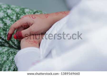 Hands of a bride decorated with henna and wedding ring. Traditional malay wedding. Soft focus image.