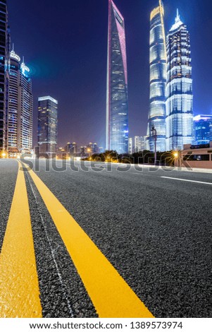 Shanghai modern commercial office buildings and empty asphalt highway at night