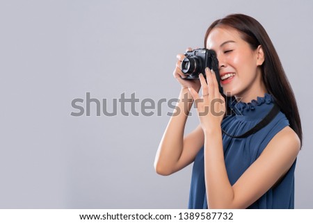 Portrait of asian woman using a vintage camera on white background, side view, Free from copy space. Photography in action.