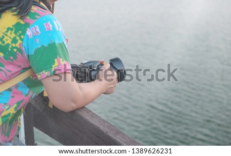 The lovely girl's arm to stay on the rails, wooden bridge Think to take a picture of what is good.