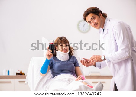 Young doctor examining injured patient 