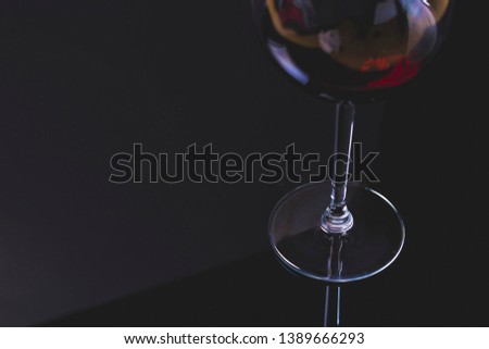 Wineglass close up with red wine on a solid black background