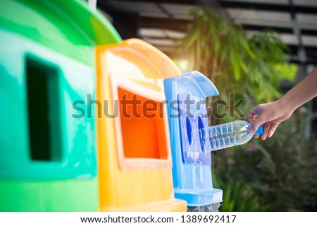 Waste management, Woman throwing plastic bottle into recycle bin. Waste separation rubbish before drop to garbage bin to save the world, environment care. Pollution trash recycling management concept. Royalty-Free Stock Photo #1389692417