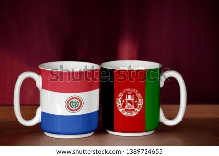 Afghanistan and Paraguay flag on two cups with blurry background