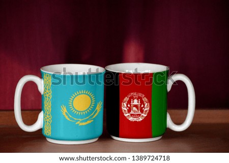 Afghanistan and Kazakhstan flag on two cups with blurry background