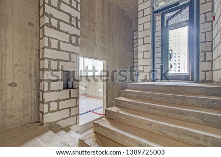 unfinished staircase to basement. Stairs architecture unfinished at basement. Cement concrete staircase on construction site. Empty and Bare Building Interior with Materials and Structure Exposed