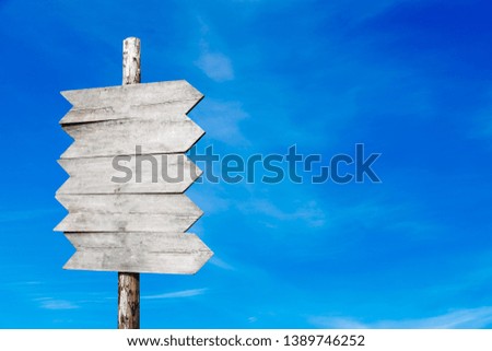 wooden signpost on a background of blue sky with clouds