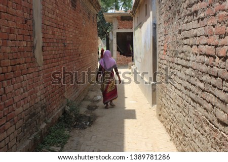 Village woman walking through a road
