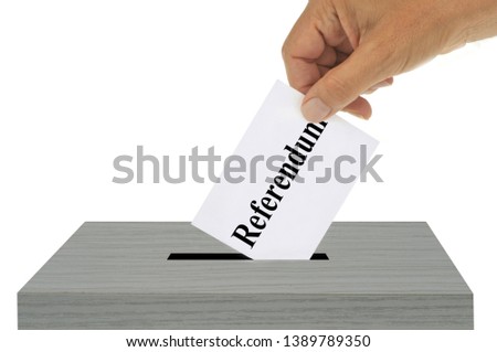 Referendum concept with someone putting a ballot in a ballot box Royalty-Free Stock Photo #1389789350