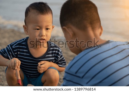 asian boys playing on the beach