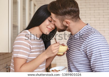 Cute young couple having breakfast in kitchen