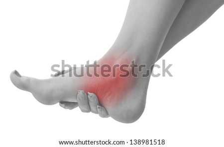 Pain in a woman ankle. Female holding hand to spot of ankle-ache. Concept photo with Color Enhanced blue skin with read spot indicating location of the pain. Isolation on a white background. 