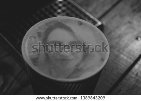 Drawing of a woman's face on a foam coffee latte in a glass created by coffe printer close-up. Coffe printer created a portrait of a girl on the foam of brewed coffee