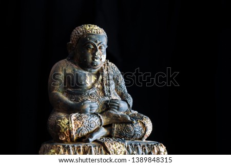 old buddha statues close up isolated on black background with window lights