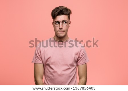 Young cool caucasian man confused, feels doubtful and unsure. Royalty-Free Stock Photo #1389856403