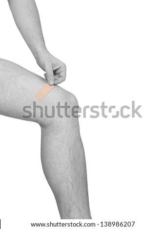 Adhesive bandage plaster on the knee. Concept photo with Color Enhanced skin with read spot indicating location of the pain.