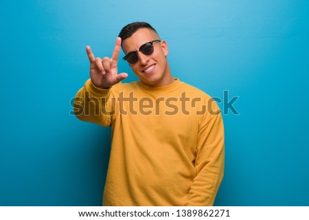 Young colombian man doing a rock gesture