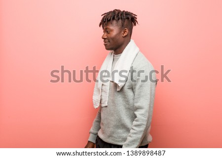 Young fitness african black man looks aside smiling, cheerful and pleasant.