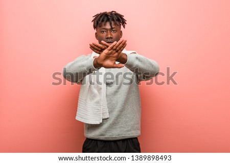 Young fitness african black man doing a denial gesture