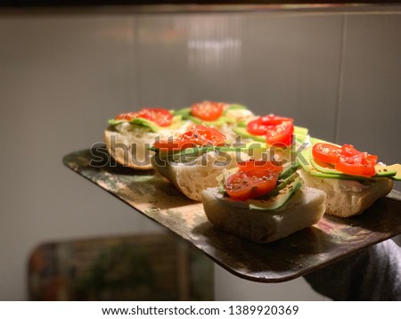 Bread with avocado and cherry in girl hand