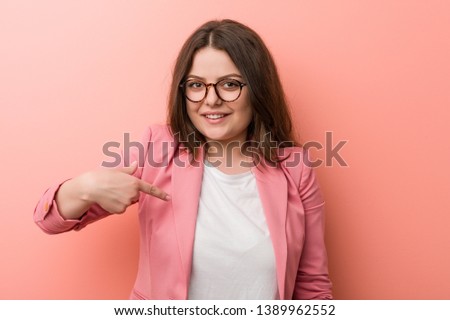 Young plus size business caucasian woman person pointing by hand to a shirt copy space, proud and confident