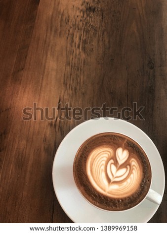 A cup of coffee on wooden table. Good morning! Start the day with a cup of Cappuccino.The morning coffee smell is always refreshing.