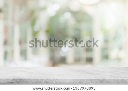 Empty white stone marble table top and blurred of interior room with window view green from tree garden background background - can used for display or montage your products.