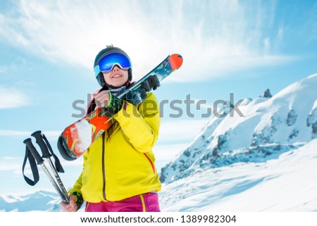 Photo of smiling woman with snowboard on background of snowy hills
