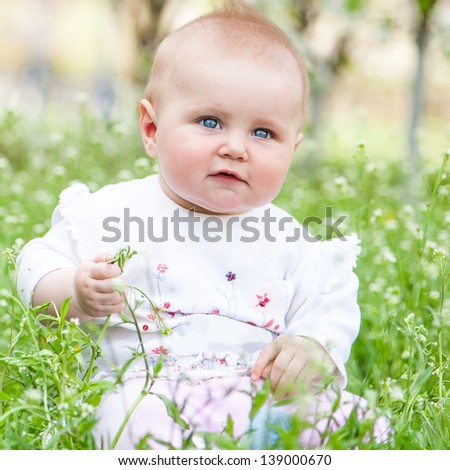 Cute baby on the meadow on a sunny summer day