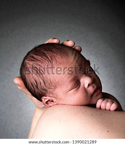 baby in mother's arms  after having a good sleep in bed with grey background stock image and stock photo