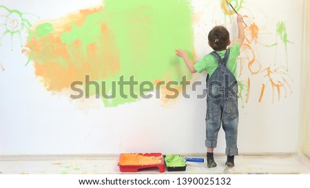 Little artist painting white wall, amusing child have fun  Royalty-Free Stock Photo #1390025132