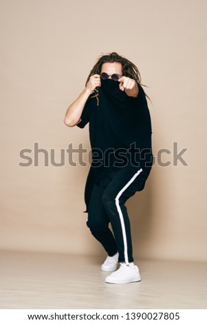 A man in fashionable clothes dancing hip-hop balance fun