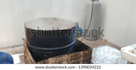 Dipping utensils in boiling water in a Passover barrel