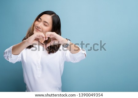 Woman in love showing love sign isolated over blue background