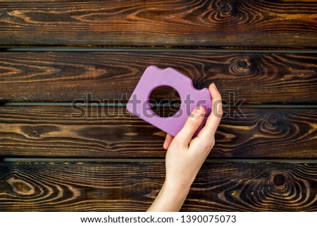 photo camera concept with hand on wooden background top view mock up