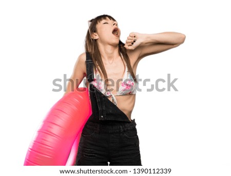 Young woman in bikini yawning and covering wide open mouth with hand over isolated white background