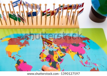Geography exercise for children, place flags of countries on a map, close-up of Spain.