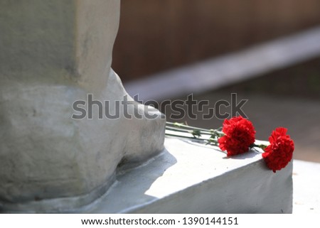 monument men and red flowers near by on victory day 9 of may in russia 