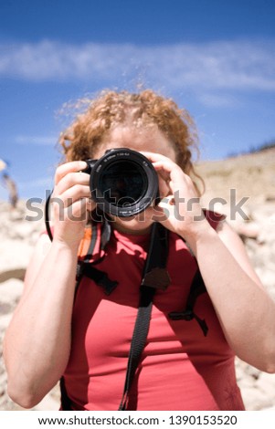 Young woman taking pictures with a DSLR camera