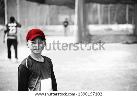 Young boy wearing red caps standing in a ground unique photo