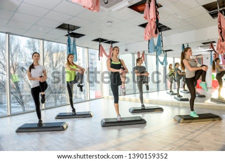 Group of women in gym making balancing exercises