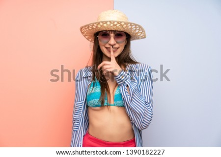 Young woman in bikini doing silence gesture
