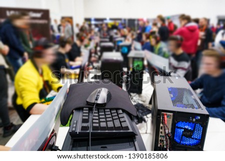 Mouse, keyboard and PC tower, selective focus. Professional gamers during a competition in the blurred background.