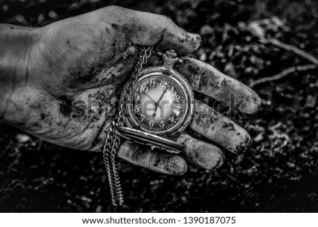 Man holding an old clock found in the ground.
