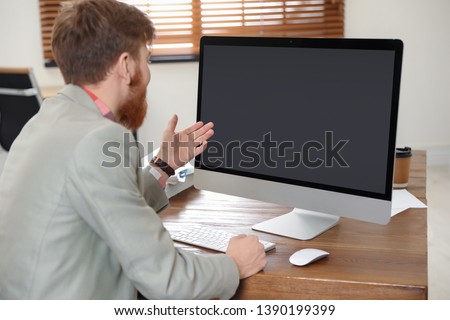 Man using video chat on computer in home office. Space for text