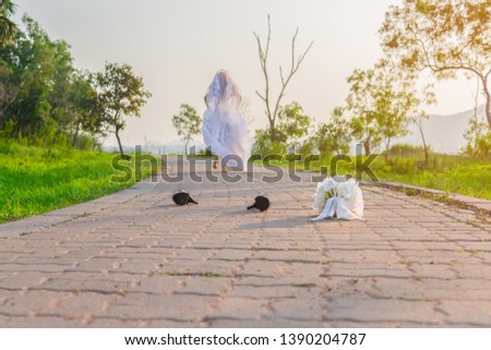 Beautiful bride wearing a white wedding dress running away alone in nature outdoor with leaving a bouquet of flowers and shoes on the street. Runaway bride before the wedding ceremony concept. Royalty-Free Stock Photo #1390204787