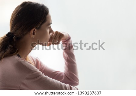 Sad woman close up side view pose aside copy space for text, girl holds hand near mouth indecision posture, feels uncertain nervous difficult to make decision, unwanted pregnancy and abortion concept Royalty-Free Stock Photo #1390237607